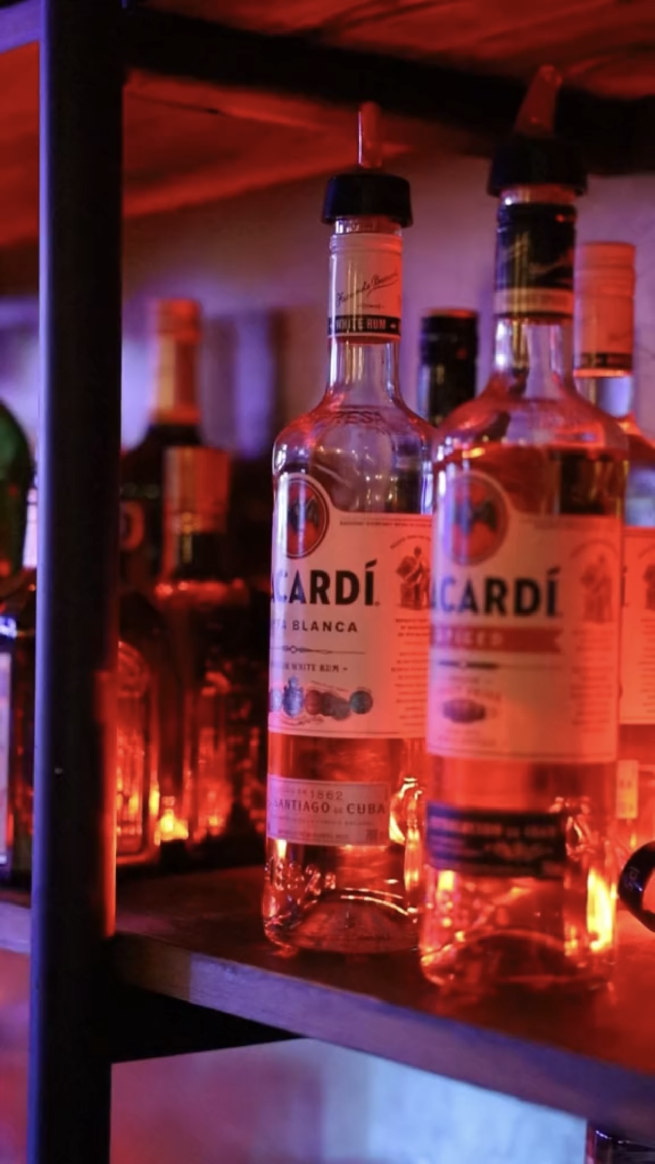 Backlit Bacardi bottles glowing behind the DownTown bar